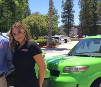 SERVPRO crew member next to green SERVPRO car