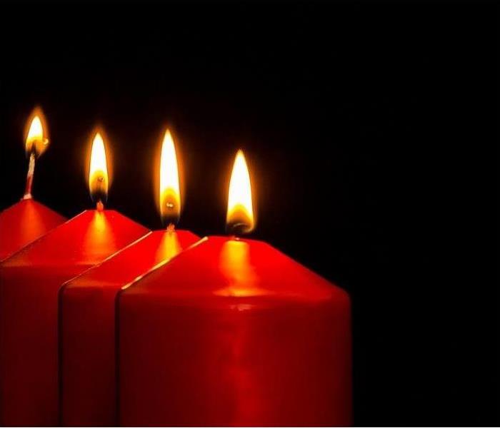 Photo is depicting four red candles that are all lit